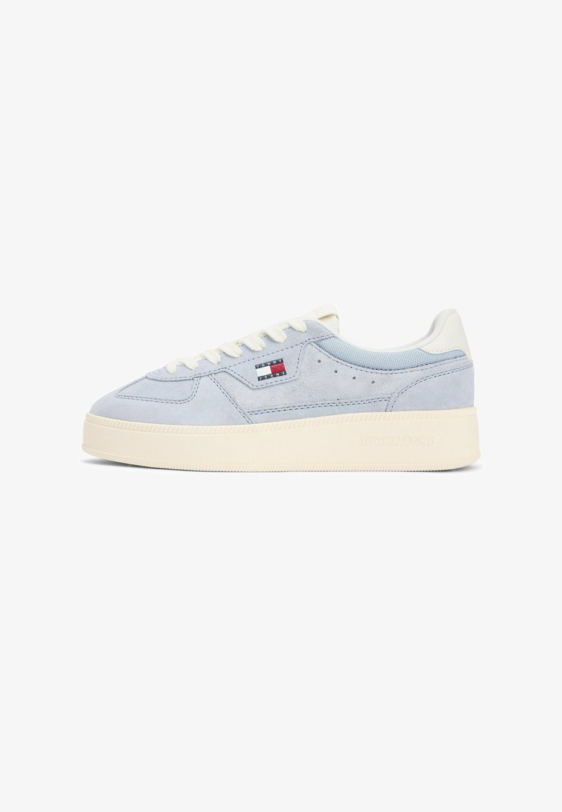 Light blue suede sneaker with white laces, cream sole, and Tommy Jeans flag logo on the side.