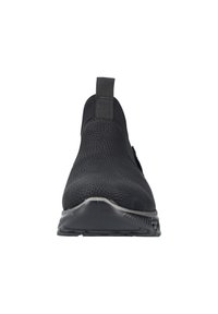Chaussure noire à enfiler avec une tige texturée et granuleuse, un panneau latéral élastique et une semelle en caoutchouc contrastante, dotée d'une solide languette à l'arrière.