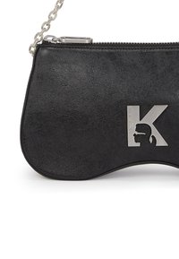 Borsa a tracolla in ecopelle nera con una tracolla in catena argentata e un accento in metallo a forma di 'K'. Superficie testurizzata. Chiusura con zip.