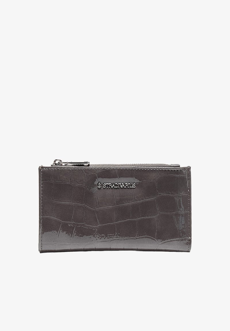 Portefeuille gris foncé avec texture crocodile, fermeture éclair en haut et logo argenté "Stradivarius" sur le devant.