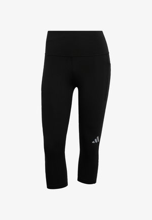 Leggings noirs courts en matériau extensible, avec une taille haute et un petit logo gris près de la partie inférieure de la jambe gauche.