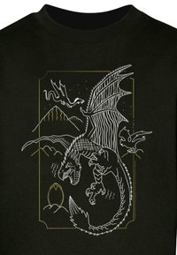 Tricou negru cu un design de dragon alb și auriu, care prezintă solzi, aripi și munți intricate, având un ou evidențiat în partea de jos.
