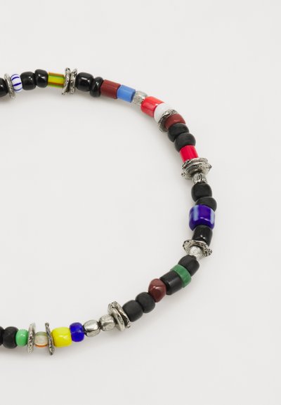 Multicolored bead necklace featuring black, red, green, blue, and white beads, with silver hardware and varied textures and shapes.