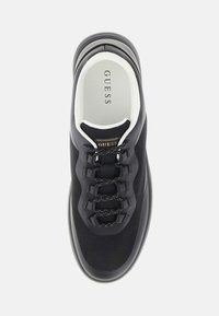 Sneaker GUESS noir avec doublure intérieure blanche, tige en mesh, lacets à motif réfléchissant et semelle épaisse et rembourrée, vue de dessus.
