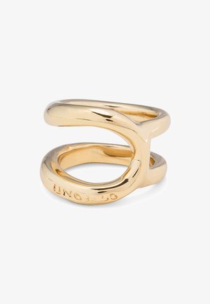Bague en ton or conçue avec une forme entrelacée en boucle, présentant une finition lisse et brillante. Gravée avec "UNO."