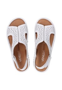 Weiße perforierte Ledersandalen mit offenem Zeh, geschlossenem Rücken und verstellbaren Riemen. Sie verfügen über eine strukturierte, hellbraune Innensohle und eine weiße Gummisohle.