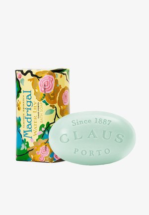 Madrigal Water Lily bath soap, mint green oval shape, embossed with "CLAU" and "PORTO," next to colorful floral packaging with gold accents.