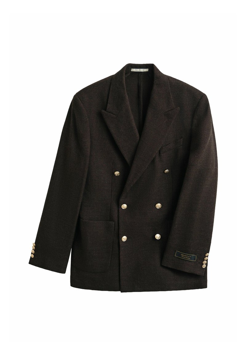 Dark brown double-breasted blazer with wide lapels, gold buttons, a patch pocket, and a small label on the left sleeve cuff.