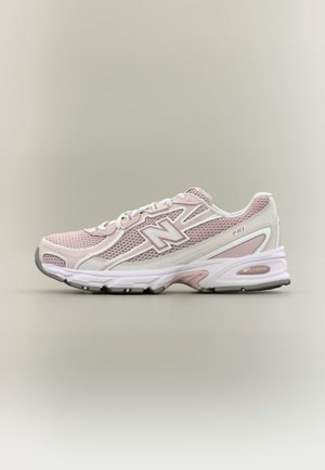 Jasnoróżowe i białe buty do biegania New Balance 740 z cholewką z siateczki i tworzywa sztucznego, białymi sznurowadłami i amortyzującą podeszwą na neutralnym tle.