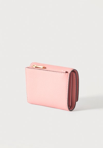 Portefeuille compact en cuir rose texturé avec fermeture éclair dorée, design plié et plusieurs compartiments, présenté sur un fond gris clair.