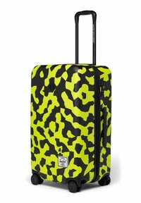 Valise rigide avec motif abstrait en jaune fluo et noir, poignée télescopique noire, poignée latérale, quatre roulettes et serrure à combinaison.