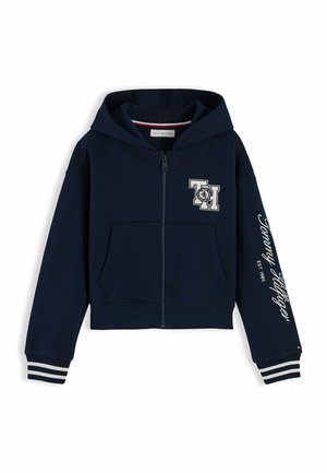 Navyblauer Kapuzenpullover mit Reißverschluss, Fronttaschen, gestreiften Bündchen, "TH" Logo auf der Brust und "Tommy Hilfiger EST 1985" Text am Ärmel.