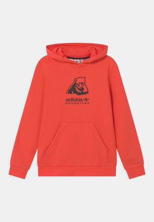 Czerwona bluza z kapturem z kieszenią z przodu, czarnym logo "adidas ADVENTURE" i kapturem. Wykonana z miękkiego materiału z ściągaczami przy rękawach i u dołu.