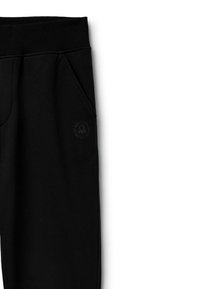 Schwarze Jogginghose aus weichem Material, mit einem elastischen Bund, Seitentaschen und einem kleinen Logo, das an der unteren Seite aufgedruckt ist.