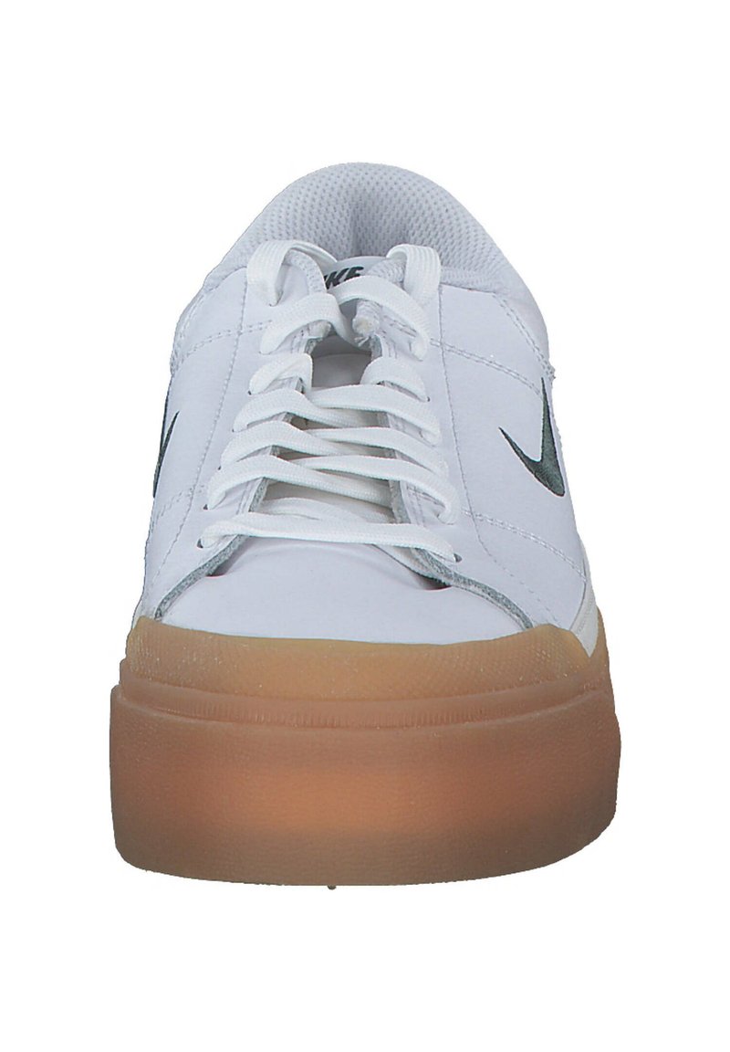 Zapatillas de cuero blancas con punta redonda, cordones en la parte delantera y suela de goma color caramelo; presentan un logo de Nike en gris en cada lado.