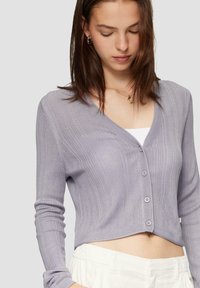 Paarse geribbelde cardigan met lange mouwen, V-hals en knoopsluiting. Kenmerkt zich door een cropped ontwerp en zachte, gestructureerde stof.
