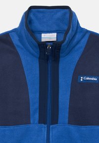 Fleec jakna u plavoj i tamnoplavoj boji, s visokim ovratnikom, punim patentnim zatvaračem, teksturiranom tkaninom i Columbia logotipom na prsima.