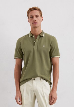 Olijfgroene polo met witte accenten, korte mouwen en een drieknoopssluiting. Voorzien van een subtiele logo op de borst.
