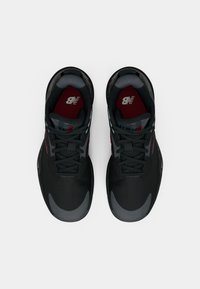 Μαύρα αθλητικά παπούτσια με γκρι λεπτομέρειες, διχτυωτή επάνω επιφάνεια και στρογγυλή μύτη. Διαθέτουν λευκές κορδόνες και κόκκινο λογότυπο στην εσωτερική επένδυση.