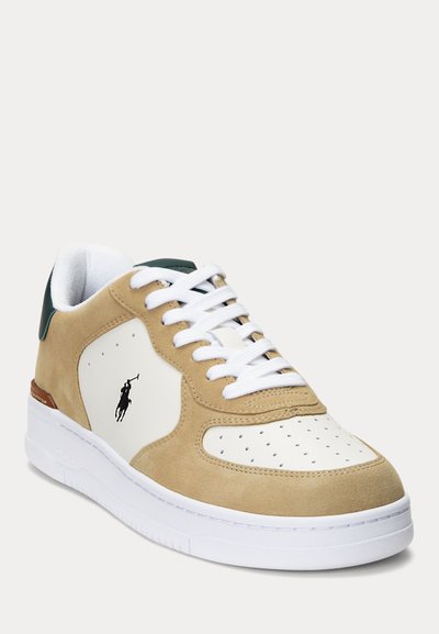 Beżowo-białe niskie tenisówki z białymi sznurowadłami, perforowanym noskiem, ciemnozielonym uchwytem na pięcie i czarnym logo gracza polo na bocznej części.