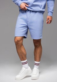 Pantaloni corti blu chiaro in morbido misto cotone, con vita elasticizzata e cordoncino, tasche laterali e dettaglio con logo.