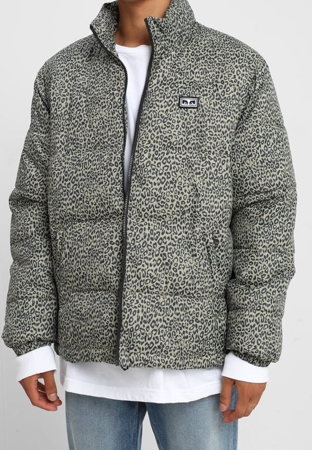 Kurtka ocieplana w kolorze szarym z czarnym motywem panterki. Posiada wysoki kołnierz, zapięcie na zamek i naszywkę z logo na lewej piersi. Miękka w dotyku.