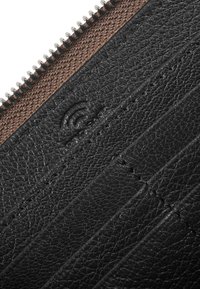 Portafoglio in pelle nera con un design testurizzato caratterizzato da scanalature orizzontali, accentuato da una chiusura con zip in tessuto marrone e hardware in argento.
