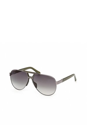 Lunettes de soleil de style aviateur avec verres foncés dégradés et branches vert olive, dotées d'un double pont métallique et d'une monture fine.