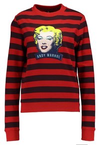 Sudadera a rayas rojas y negras con un gráfico de Marilyn Monroe con cabello amarillo y el texto "ANDY WARHOL" en el pecho.