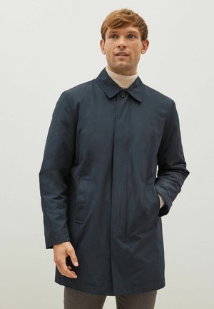 Palton bleu marin cu guler, închidere frontală cu nasturi și buzunare laterale. Fabricat dintr-un material neted și ușor, având o croială dreaptă.