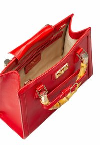 Rote Ledertasche mit strukturierter Form, goldfarbenen Beschlägen und Akzenten aus Bambus. Das Innere hat ein beiges Futter und mehrere Fächer.
