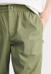 New Balance Tygbyxor - olive