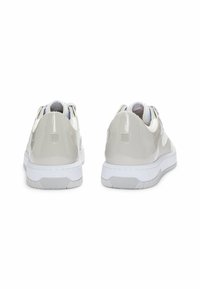 Hugo sneakers in glossy light gray patent leather with a white rubber sole, featuring a padded collar and a subtle logo on the heel.