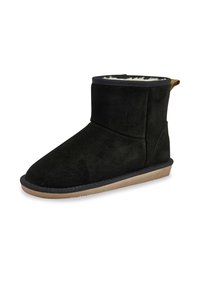 Botín de ante negro con un suave forro interior, perfil bajo, suela plana y un pequeño lazo cosido en la parte trasera para facilitar su uso.