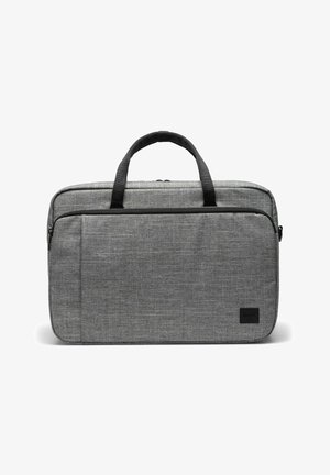 Sacoche pour ordinateur portable en tissu gris avec poignées noires, poche frontale zippée, et forme rectangulaire compacte conçue pour transporter des appareils électroniques.