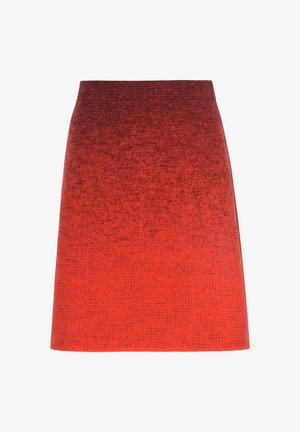 Falda roja en línea A con un sutil patrón degradado de manchas negras, cintura alta y textura suave sobre un fondo blanco.