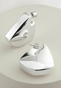Cercei geometrice din argint cu o suprafață lustruită, având un design triunghiular și închidere cu spatele post. Textură netedă și finisaj reflectorizant.