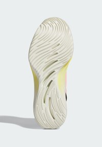 Sål af en atletik sko med bølget tekstur i off-white og lys gul, med en pink og sort øverste del synlig ved hælen.
