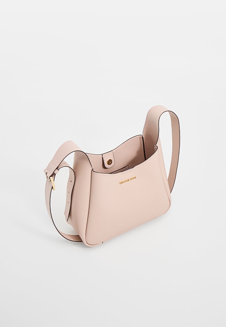 Sac à main en cuir rose clair avec une forme structurée, un haut ouvert et une bandoulière réglable. Présente un logo doré et une texture lisse.