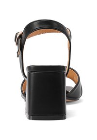 Sandalo con tacco in similpelle nera, caratterizzato da un tacco massiccio e una fascia alla caviglia. Texture liscia e design minimalista, con un semplice dettaglio a fibbia.