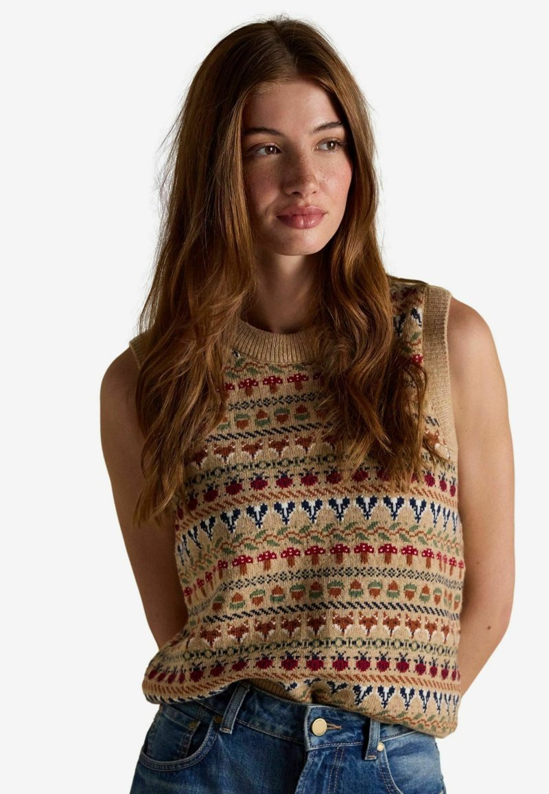 Kootud varrukateta sviiter beeži värviga, millel on mitmevärvilised lille- ja geomeetrilised musterid. Koos teksadega, millel on nupuga sulgemine.