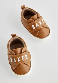 Sneakers per toddler in pelle marrone con fascia in velcro bianca che presenta la scritta "BAKER", punta rotonda e suola in gomma bianca. Foderato internamente in modo morbido.