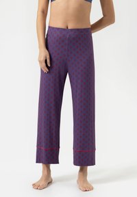 Navy pyjamabroek met een rood bloemenpatroon, wijde snit en een zoom met een contrasterende rode bies. Zachte, ademende stof.