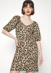 Vestido de padrão de leopardo com uma silhueta ajustada, mangas curtas bufantes e decote arredondado. Feito de tecido texturizado, com detalhes em preto.