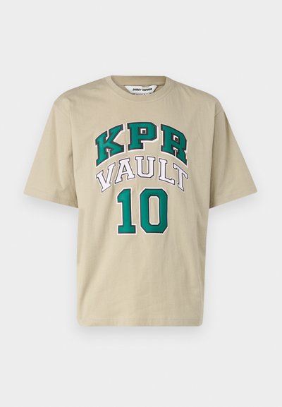 Bežs kokvilnas T-krekls ar īsām piedurknēm, kuram ir liels "KPR VAULT 10" grafiks zaļā un baltā krāsā. Mīksta tekstūra un brīvs piegriezums.