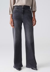 Hoch taillierte, weit geschnittene Jeans aus dunklem Grauen Denim. Mit subtilen Used-Effekten, Fünf-Taschen-Design und einem klassischen Knopfverschluss an der Taille.