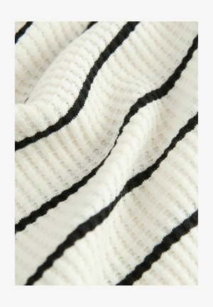 Tkanina bawełniana o teksturowanej powierzchni, z pionowymi czarnymi paskami na białym tle, tworzącymi żebrowany wzór.