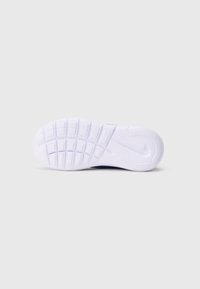 Semelle en caoutchouc blanche d'une sneaker avec des motifs de grip texturés et des accents courbés, mettant en avant un design antidérapant et une durabilité.