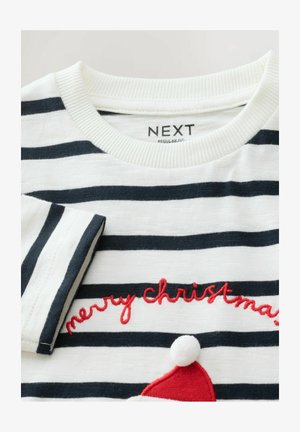 Bela in mornarsko modra črtasta srajca z dolgimi rokavi in rebrastim ovratnikom; vsebuje rdeč vezen napis "vesel božič" in podrobnost rdeče božične kape.