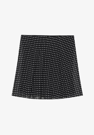 Melna svārku ar baltiem punktiņiem, ar krokojumu un gludu tekstūru. Tam ir izliekts apakšmala un vienkāršs jostas dizains.